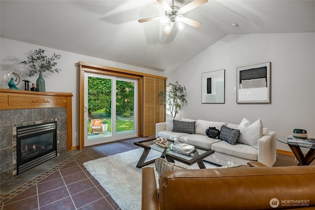 living room with a ceiling fan, dark tile patterned flooring, a fireplace, and lofted ceiling