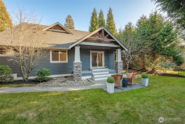 craftsman inspired home featuring a shingled roof and a front lawn