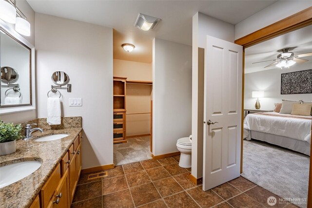 full bathroom featuring toilet, ensuite bath, a ceiling fan, and a sink