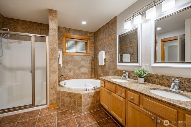 bathroom with double vanity, a sink, a shower stall, and a bath