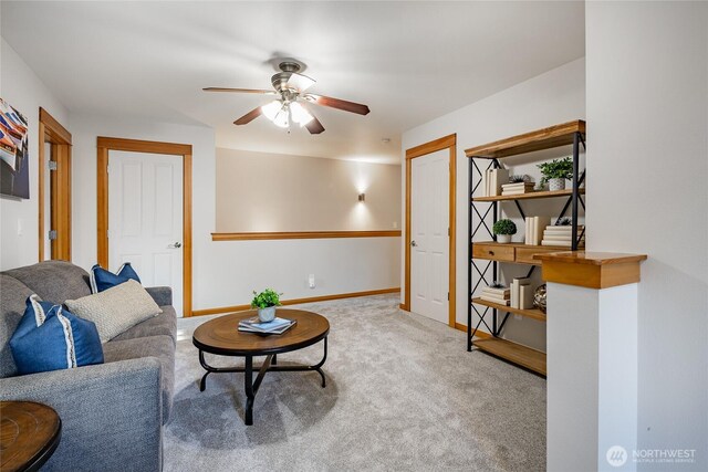 living room with carpet floors, a ceiling fan, and baseboards