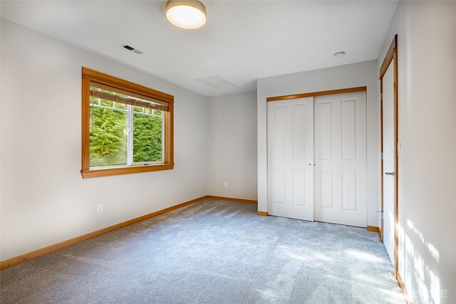 unfurnished bedroom with light carpet, a closet, visible vents, and baseboards