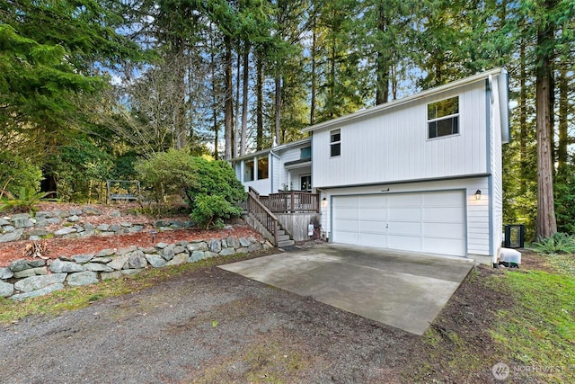 raised ranch with stairs, an attached garage, and driveway