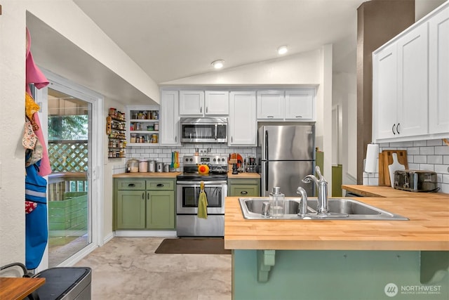 kitchen featuring a sink, stainless steel appliances, green cabinets, butcher block counters, and lofted ceiling