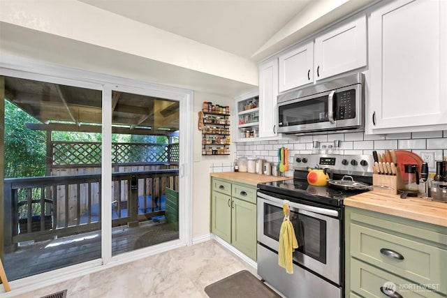 kitchen featuring decorative backsplash, butcher block counters, stainless steel appliances, and green cabinets