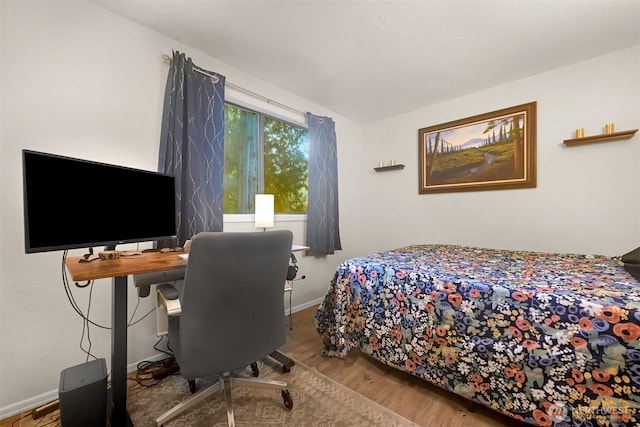 bedroom with baseboards and wood finished floors