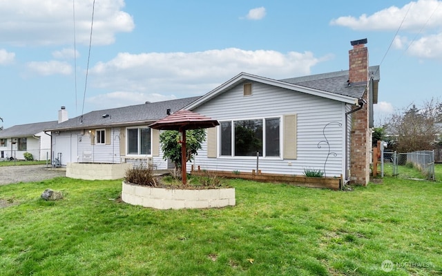 back of house with a shingled roof, a yard, fence, and a chimney