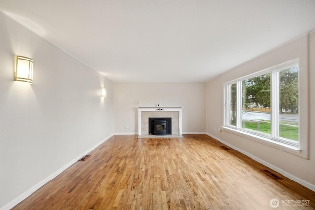 unfurnished living room featuring visible vents, baseboards, and light wood-style flooring