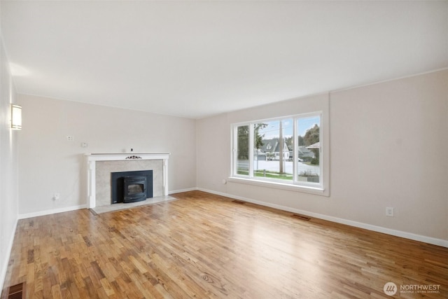 unfurnished living room with visible vents, baseboards, and light wood finished floors