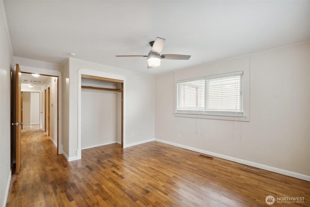 unfurnished bedroom with visible vents, baseboards, a closet, and wood finished floors