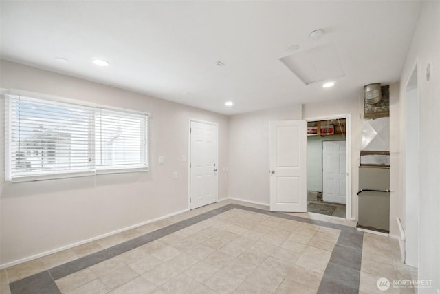 spare room with attic access, recessed lighting, and baseboards