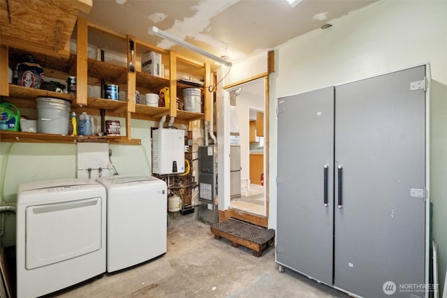 washroom with water heater, laundry area, and washer and dryer