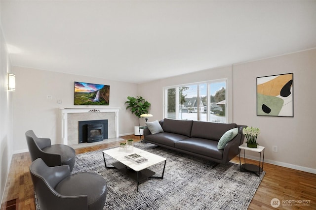 living room featuring visible vents, baseboards, and wood finished floors