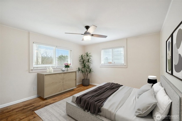 bedroom with ceiling fan, baseboards, and wood finished floors