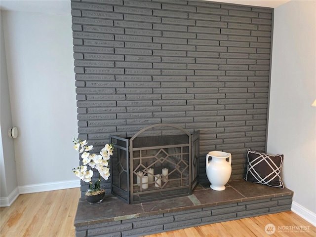 details featuring a fireplace, baseboards, and wood finished floors