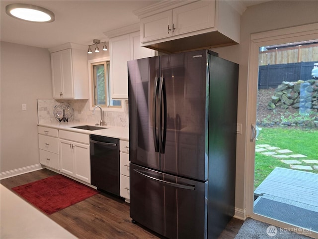 kitchen with dark wood finished floors, decorative backsplash, freestanding refrigerator, a sink, and dishwasher