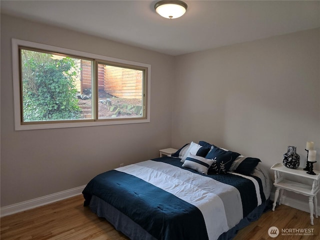 bedroom featuring wood finished floors and baseboards