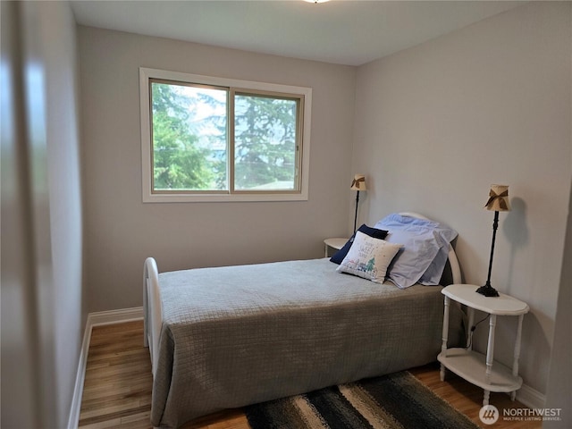 bedroom featuring baseboards and wood finished floors