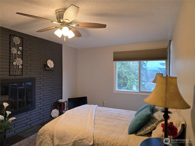 bedroom featuring a textured ceiling, a fireplace, and a ceiling fan