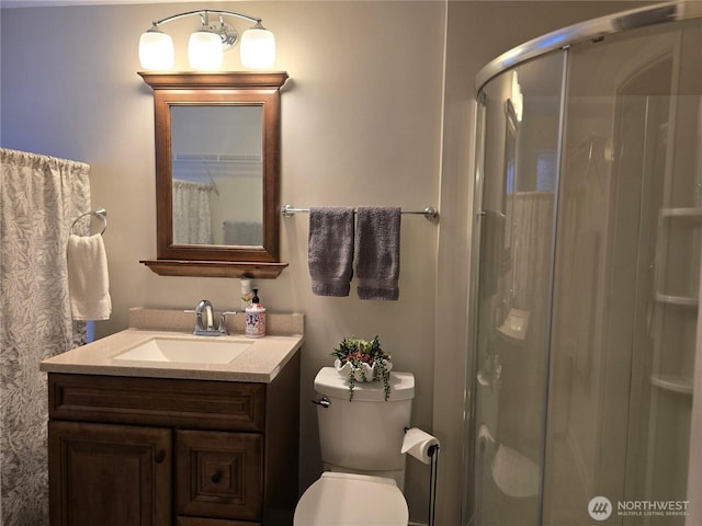 bathroom featuring a stall shower, vanity, and toilet