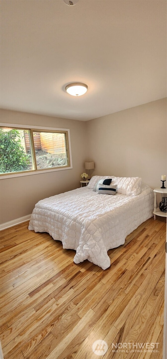 bedroom with wood finished floors and baseboards