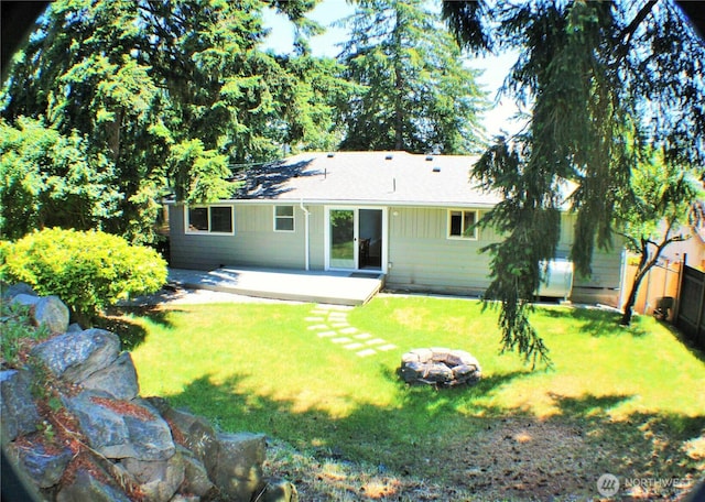 rear view of property featuring fence, a yard, and a patio