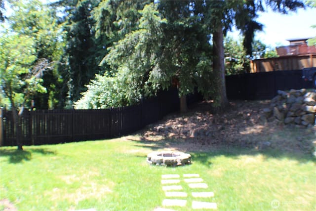 view of yard with a fire pit and fence