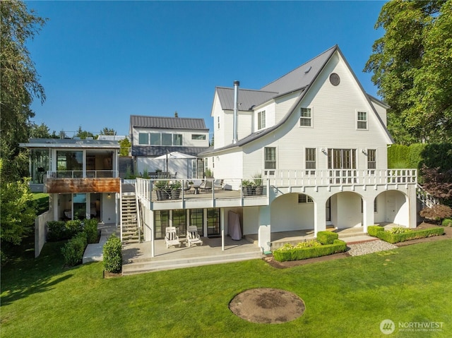 rear view of property featuring stairs, a yard, and a patio area