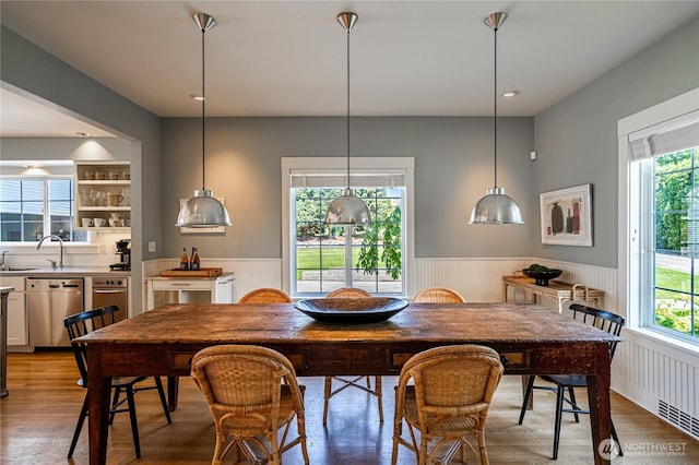 dining room with wood finished floors and a wainscoted wall