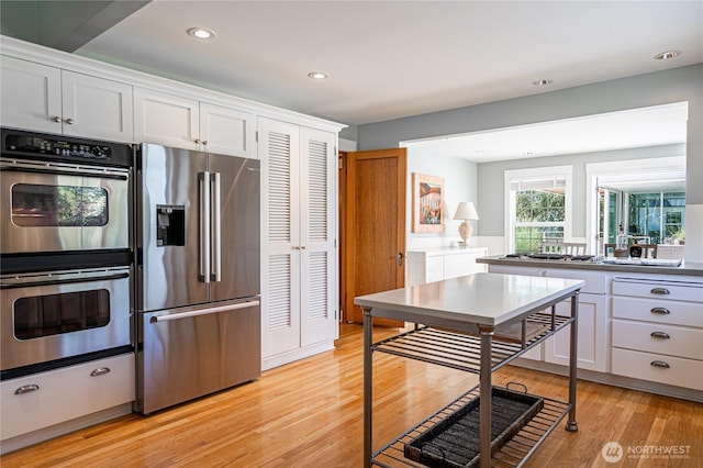 kitchen with white cabinetry, light wood finished floors, recessed lighting, and appliances with stainless steel finishes