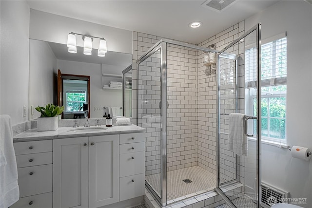 full bathroom with recessed lighting, visible vents, a shower stall, and vanity