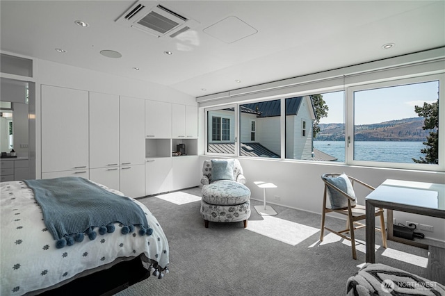 carpeted bedroom featuring vaulted ceiling, visible vents, recessed lighting, and a water view