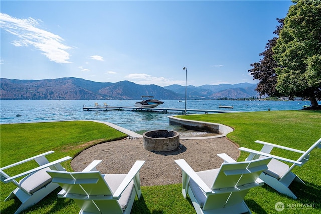 exterior space with an outdoor fire pit and a water and mountain view