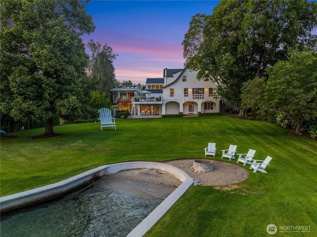 view of yard with a fire pit, a balcony, and a patio