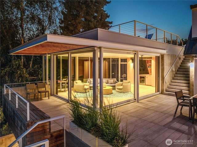 rear view of house with stairs and a sunroom