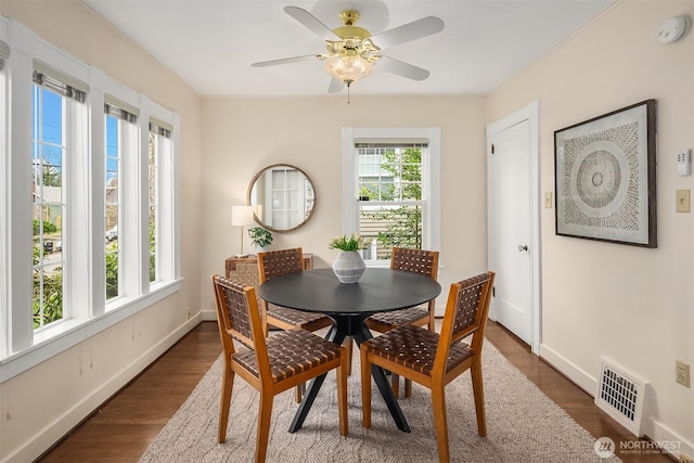 dining area featuring visible vents, baseboards, and dark wood-style flooring