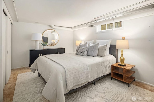 carpeted bedroom featuring baseboards and visible vents