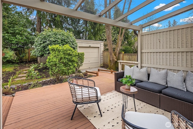 deck with an outbuilding, a fenced backyard, a pergola, and an outdoor hangout area