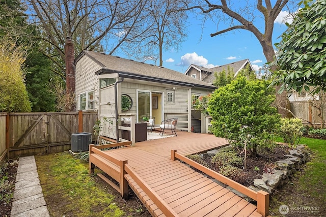 wooden deck with central air condition unit, a gate, and fence