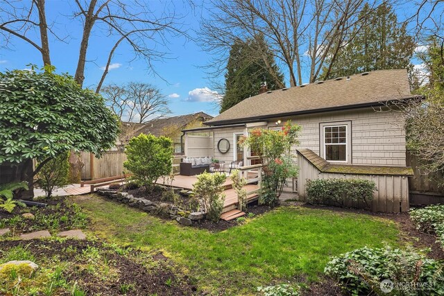 back of house with fence, a wooden deck, a yard, a chimney, and outdoor lounge area