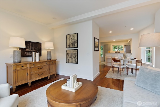 living room featuring baseboards, ornamental molding, wood finished floors, and recessed lighting