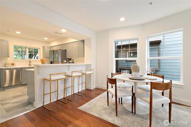 dining area with light wood finished floors, visible vents, baseboards, and recessed lighting