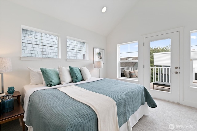 carpeted bedroom with vaulted ceiling and access to exterior