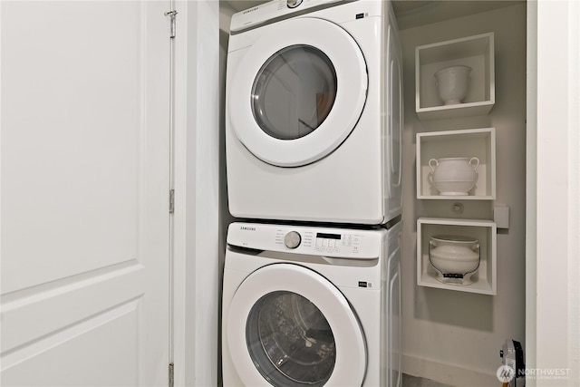 clothes washing area with stacked washer and clothes dryer and laundry area