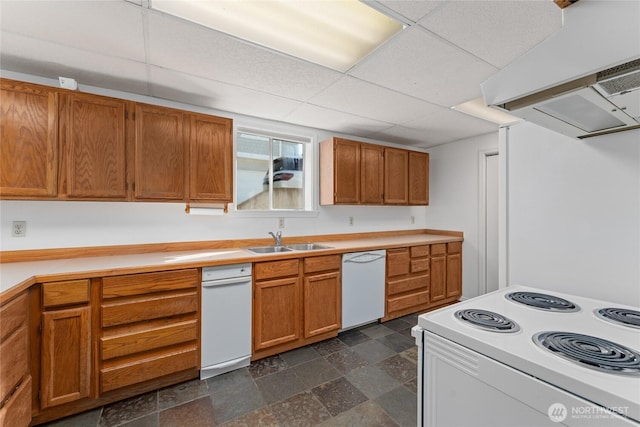 kitchen with white appliances, brown cabinetry, stone finish floor, light countertops, and a sink