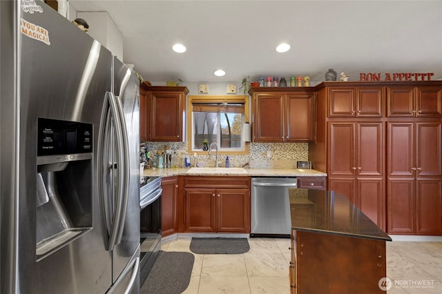 kitchen featuring tasteful backsplash, stone countertops, stainless steel appliances, and a sink