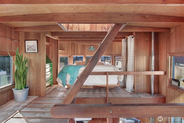 interior space with wood walls and beam ceiling