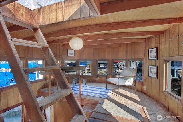 interior space with beam ceiling and wood walls