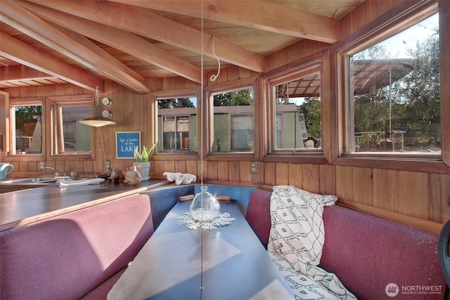 sunroom / solarium featuring beam ceiling and a sink