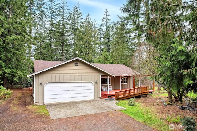 single story home featuring driveway, a garage, board and batten siding, and roof with shingles